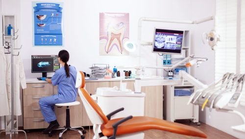 stomatology-office-with-modern-equipment-nurse-wearing-blue-uniform-working-computer stomatology-office-with-modern-equipment-nurse-wearing-blue-uniform-working-computer